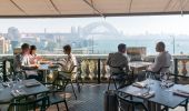 Diners enjoying food and drink with harbour views at Cafe Sydney, Sydney