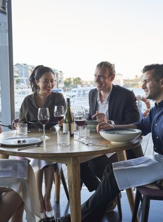 Friends enjoying food and drink at waterside restaurant LuMi Bar & Dining in Pyrmont