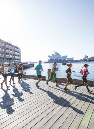Participants in the Blackmores Sydney Running Festival passing through Campbells Cove with views of the Sydney Opera House