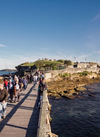 Group crossing footbridge from the historic Bare Island Fort, La Perouse