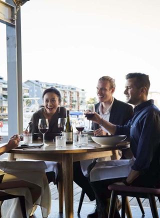 Friends enjoying food and drink at waterside restaurant LuMi Bar & Dining, Pyrmont