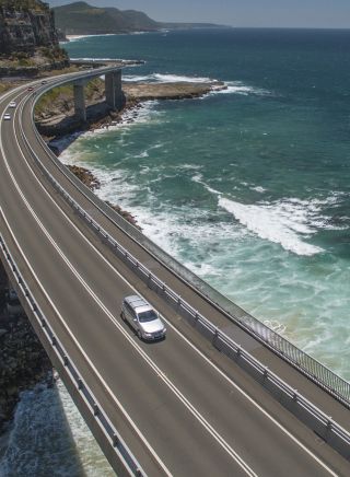 A car driving across the Sea Cliff Bridge, near Clifton