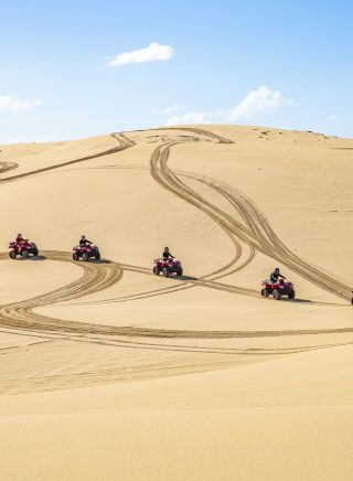 Small group enjoying an Aboriginal cultural tour on quad bikes with Sand Dune Adventures, Port Stephens