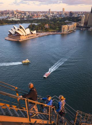 Friends enjoying a twilight BridgeClimb Sydney experience overlooking Sydney Harbour