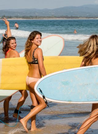 Girls getting ready to enter the surf at Wategos Beach, Byron Bay