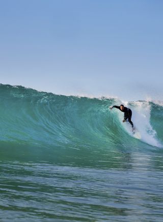 Surfer catches a wave at Mona Vale Beach