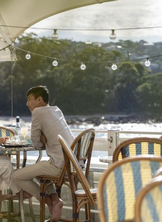 Couple enjoying food and drink with views of Balmoral Beach at Bathers Pavilion, Mosman