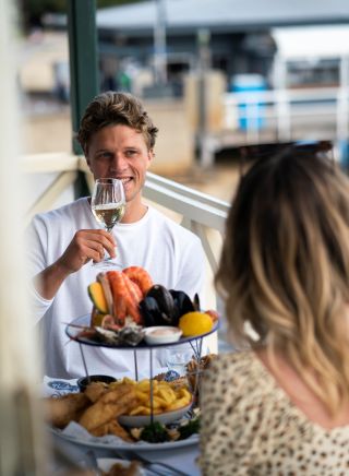 Couple enjoying a seafood platter at Doyles on the Beach Restaurant, Watsons Bay