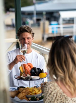 Couple enjoying a seafood platter at Doyles on the Beach Restaurant, Watsons Bay