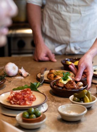 Chef preparing tapas for diners at Una MÃ¡s restaurant on the middle level of the Coogee Pavilion, Coogee