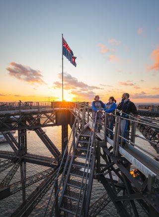 Friends enjoying a twilight BridgeClimb Sydney experience overlooking Sydney Harbour, Sydney