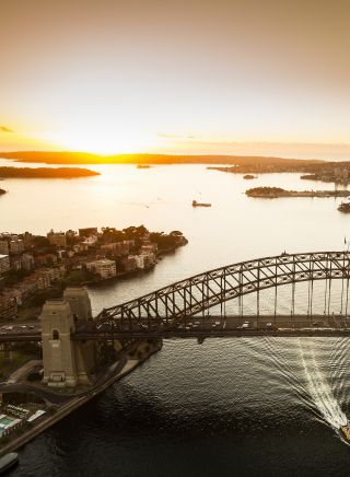 Aerial of the sun rising over Sydney Harbour with views of the Sydney Harbour Bridge