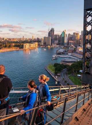 Friends enjoying a twilight BridgeClimb Sydney experience overlooking Sydney Harbour