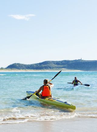 Couple enjoying a morning paddle at Palm Beach on Sydney's northern beaches