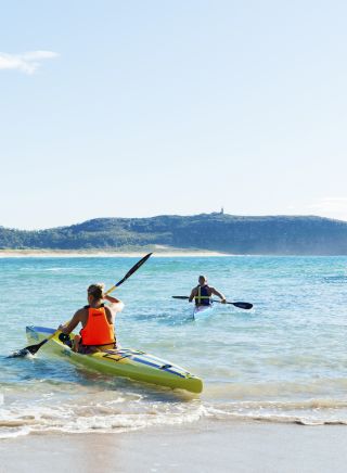 Couple enjoying a morning paddle at Palm Beach on Sydney's northern beaches.