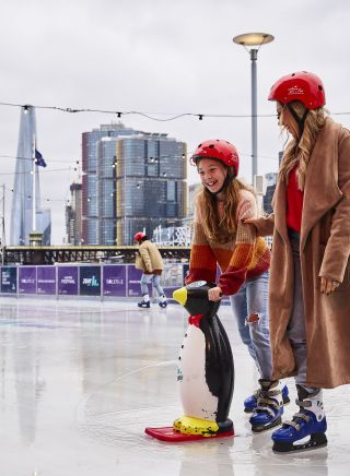 Mother and Daughter enjoying a winter ice skating session in Darling Harbour, Sydney City