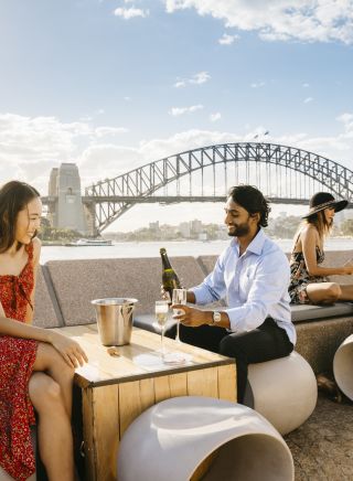 Couple enjoying champagne with harbour views at Opera Bar in Circular Quay, Sydney City
