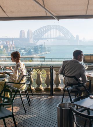 Diners enjoying food and drink with harbour views at Cafe Sydney, Sydney