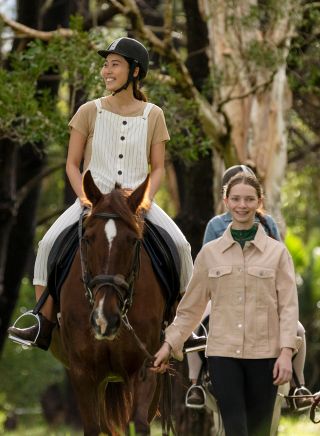 Woman enjoying a horse riding experience with East Side Riding Academy in Centennial Park, Sydney