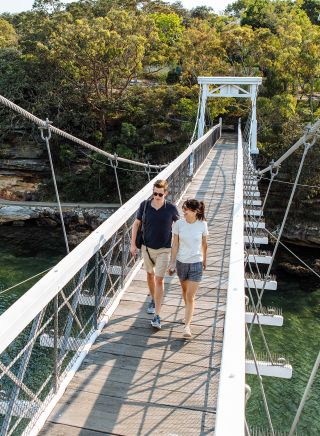 Couple walking across the footbridge at Parsley Bay, Vaucluse