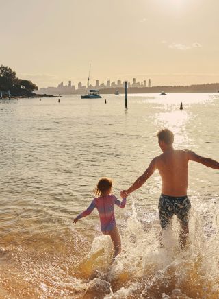 父親和孩子在沃森灣的 Camp Cove 玩水