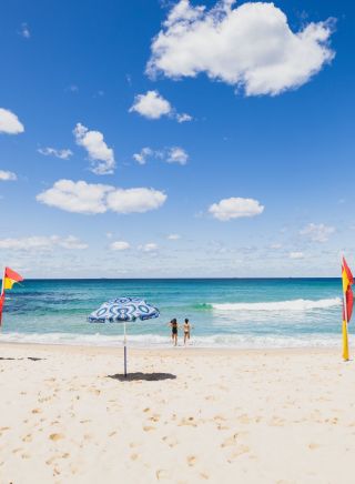 Couple running into the ocean at Tamarama Beach, Tamarama