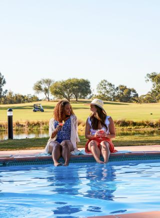 Friends relaxing by pool, Oaks Cypress Lakes Resort, Pokolbin