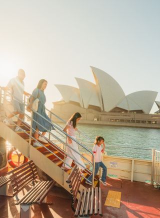 Familie geht die Treppe hinunter, im Hintergrund das Opernhaus, Sydney Harbour Fähre, Sydney