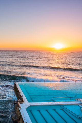 Morning sun rising over Bondi Icebergs, Bondi Beach