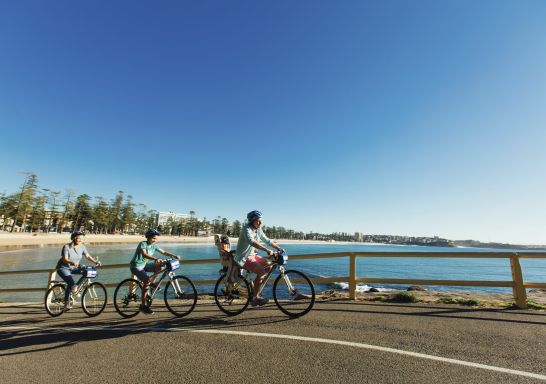 Family enjoying a bike ride at Manly Beach on Sydney's northern suburbs