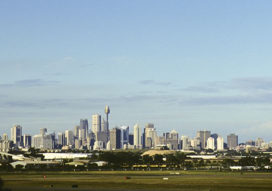 Qantas plane taking off from Sydney airport, with views to the city in the background