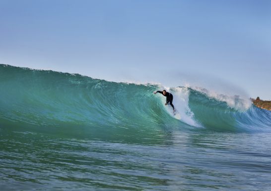 Surfer catches a wave at Mona Vale Beach