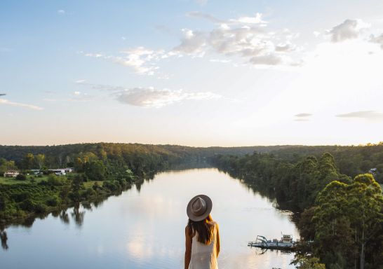 Woman enjoying scenic views across the Hawkesbury River from the Cooks Co-Op lookout, Sackville