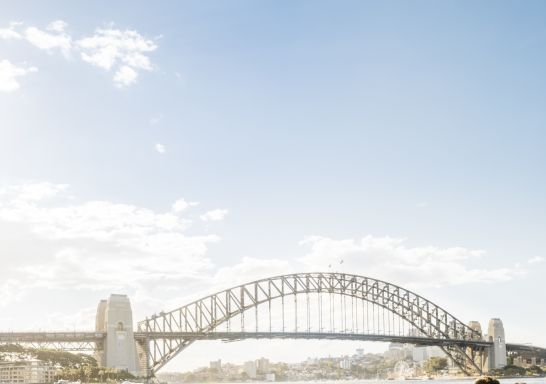 Couple enjoying food and drink with harbour views at Opera Bar, Sydney.