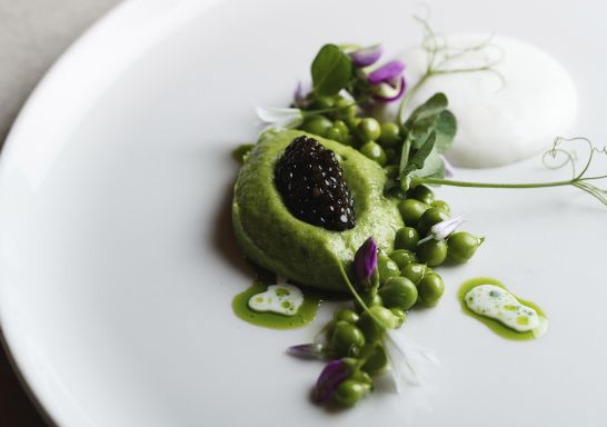 Fine dining dish on the Spring menu at Aria Restaurant, Sydney.  Dish: First of the season asparagus, spring peas, smoked milk and caviar.
