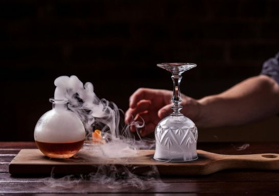  A smoking bottle on a wooden board with a hand about to turn over a smoke filled glass - Sydney - Credit Eau De VieATDW - Smokey Rob - Roy Eau De Vie - A smoking bottle on a wooden board with a hand about to turn over a smoke filled glass, Sydney - Credit: Eau De Vie