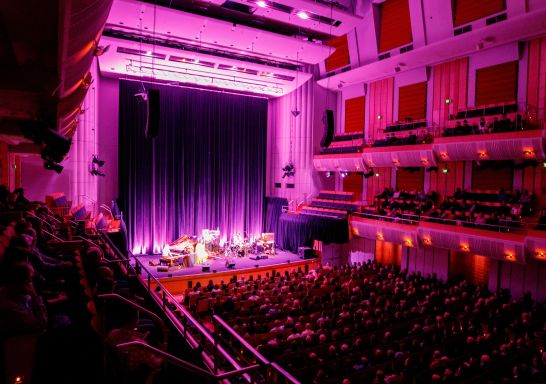 Bright fushia pink lighting on stage from audience view of people enjoying Diane Reeves event at Vivid Sydney, City Recital Hall, Angel Place, Sydney