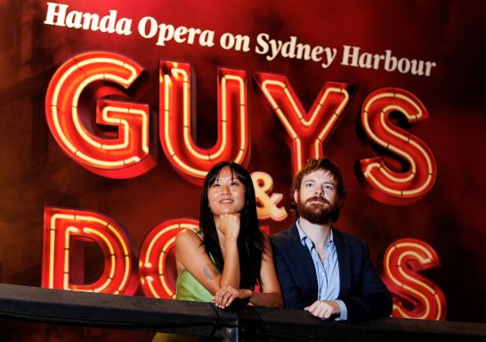 A couple enjoys the performance of Guys and Dolls, Handa Opera on Sydney Harbour, Sydney CBD